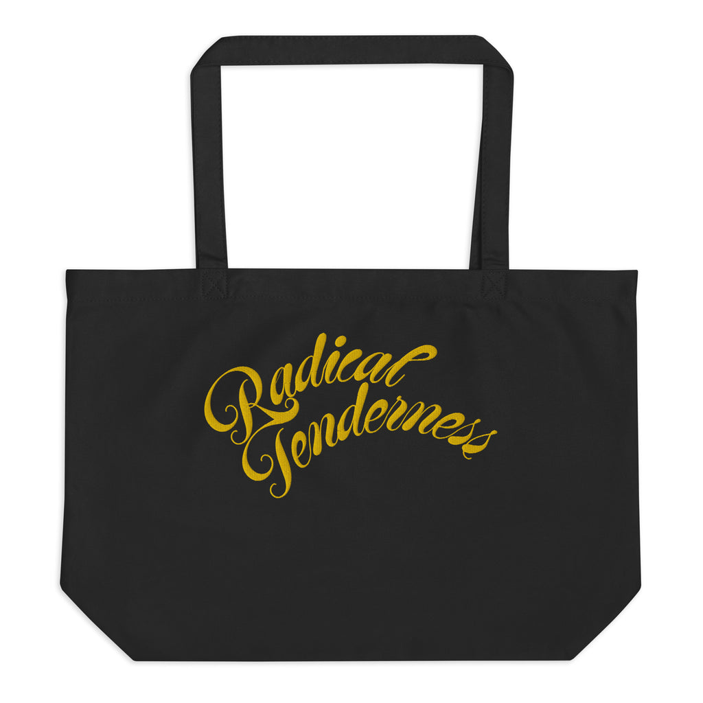 Front view of black tote with Radical Tenderness embroidered in gold cursive letters.
