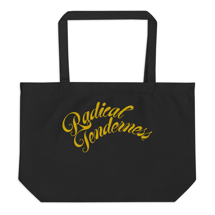 Front view of black tote with Radical Tenderness embroidered in gold cursive letters.