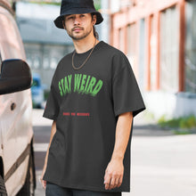 Model wearing faded oversized Stay Weird t-shirt by Heroes Are Weirdos.